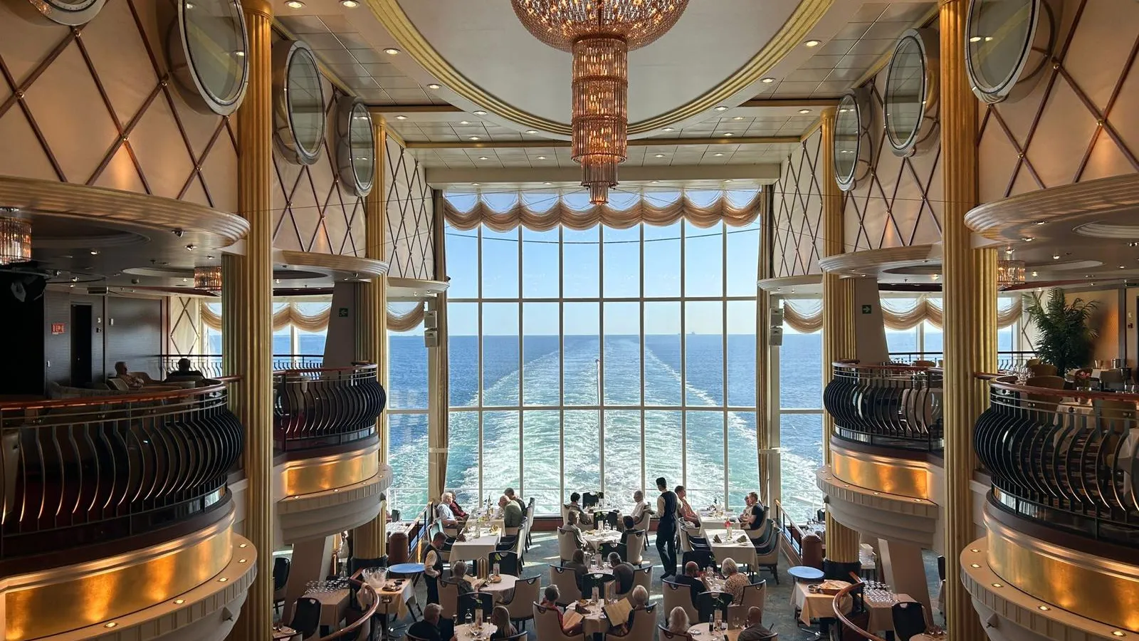 Restaurant aan boord met uitzicht op het kielzog achter het schip